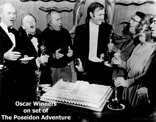 Jack Albertson, Red Buttons, Ronald Neame, Gene Hackman, Irwin Allen, Shelley Winters, and Ernest Borgnine on the set of The Poseidon Adventure with Oscar themed cake and their statuettes