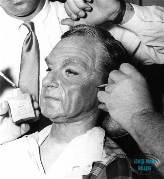 Make-up artists applying adhesive to Dr. Smith mask